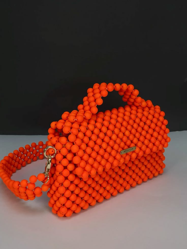 Bolso naranja de cuentas con forma firme y acabado brillante